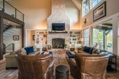 a living room filled with lots of furniture and a fire place in the middle of it