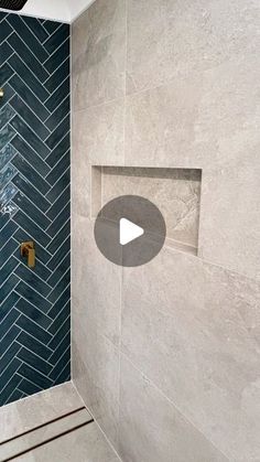 a walk in shower sitting next to a blue tiled wall with a mirror above it