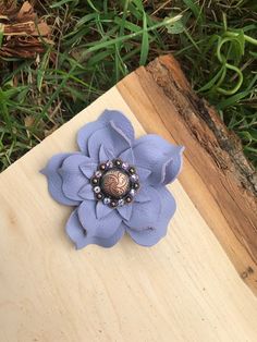 a blue flower on top of a piece of wood