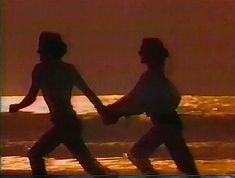 two people walking on the beach holding hands