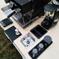 a coffee maker sitting on top of a table next to a sink and other appliances