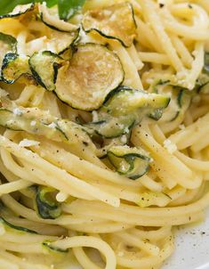 pasta with zucchini and spinach on a white plate