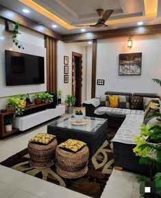 a living room filled with lots of furniture next to a flat screen tv mounted on the wall