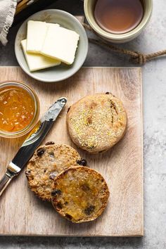 bread, jam and butter are on a cutting board