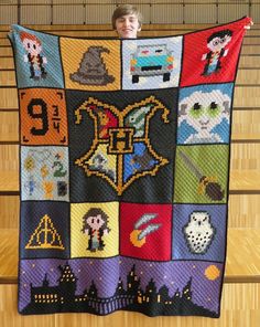 a boy holding up a harry potter quilt