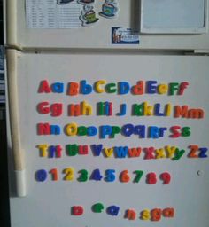 a refrigerator with magnets on the door and letters written in different colors, shapes and sizes