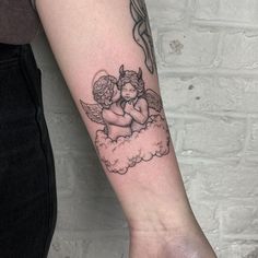 a tattoo on the arm of a woman with an angel and cloud in the sky