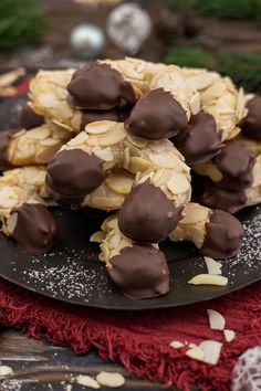 chocolate covered almonds on a plate with christmas decorations in the backgroung