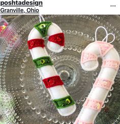 two candy canes sitting on top of a glass plate next to each other in the shape of a heart