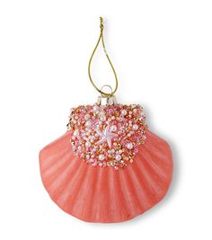 an ornament hanging from a string on a white background with pink and gold beads