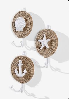 three wall hooks with sea shells and anchors on them