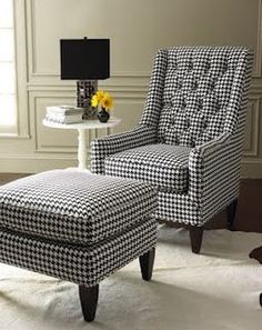 a black and white chair sitting next to a footstool in a living room