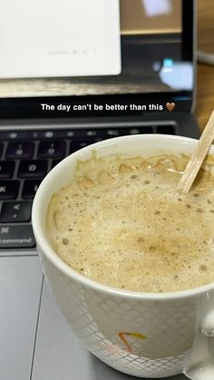 a cup of coffee sitting next to a laptop computer