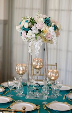 the centerpieces on this table are filled with flowers and gold rimmed glasses