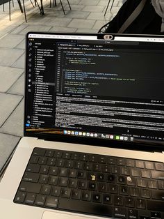 an open laptop computer sitting on top of a white table next to a black keyboard