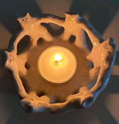 a candle is lit in a bowl shaped like an animal's paw print pattern