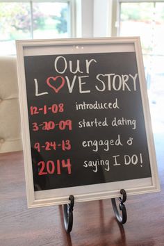 a sign that says our love story is introduced in red and white lettering on a black board