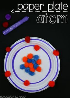 a paper plate with red, white and blue pom poms on it next to a marker