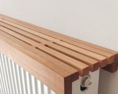 a wooden shelf mounted to the side of a wall next to a radiator