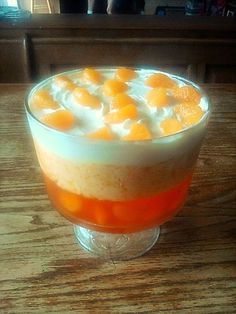 an orange and white dessert in a glass on a table