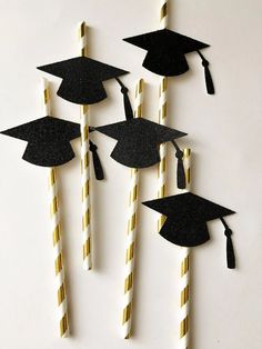 graduation decorations made out of paper straws and black caps with gold stripes on them