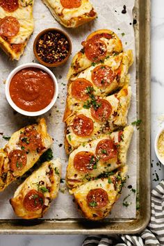 pepperoni pizza slices on a baking sheet with dipping sauces