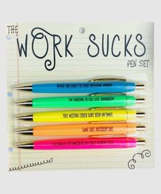 four different colored pens sitting on top of a piece of lined paper with the words, work sucks pen set