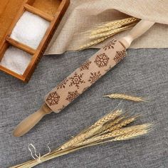 two stalks of wheat sitting on top of a table next to a wooden box and spoon