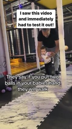 a man holding a baby in his arms while standing on top of a trampoline