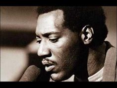 a black and white photo of a man with his head turned to the side holding a microphone