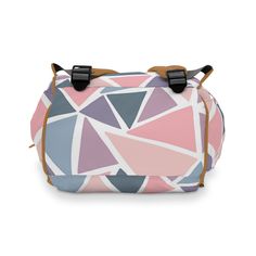 a pink, blue and purple bag with geometric shapes on the front flap is shown