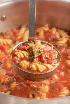 a ladle full of pasta and tomato soup