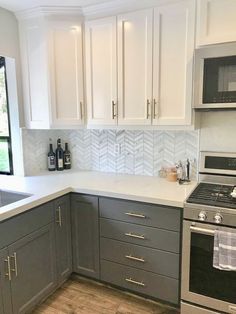 a kitchen with gray cabinets and white counter tops