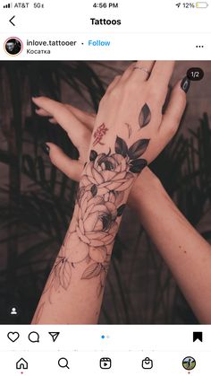 two hands with tattoos holding each other's fingers and flowers on their wrists