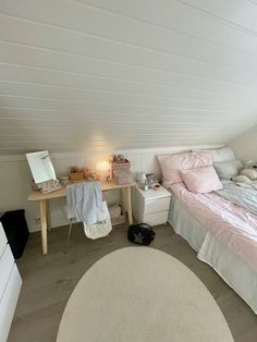 an attic bedroom with white walls and pink bedding