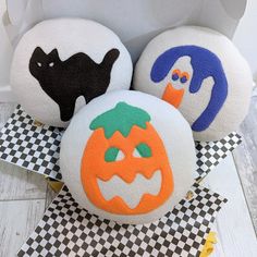 three halloween themed balls sitting on top of a checkered table cloth