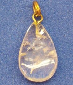 a gold plated pendant with a clear tear