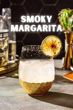 a glass filled with liquid and topped with a slice of lemon sitting on top of a table