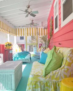 a porch with colorful furniture and striped walls