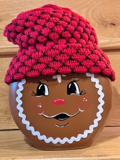 a brown pot with a red knitted hat on it's head and eyes