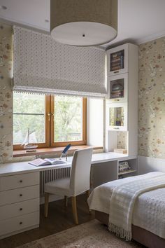 a bedroom with a bed, desk and bookshelf next to a large window