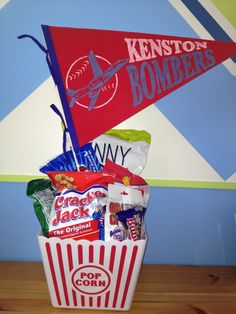 a basket filled with candy and snacks sitting on top of a wooden table next to a wall