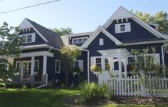 a blue house with white trim on the front and side of it's windows