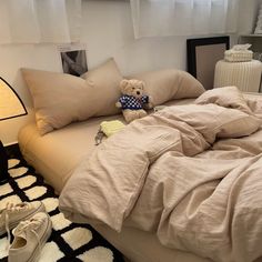 a teddy bear sitting on top of a bed in a bedroom next to a lamp