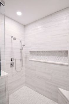 a walk in shower sitting next to a bath tub