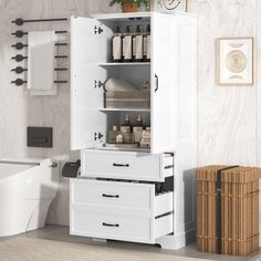 a white bathroom cabinet with drawers and baskets on the floor next to it in front of a toilet