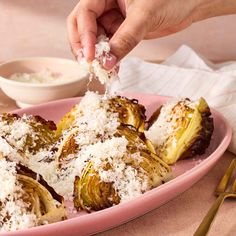 someone is sprinkling parmesan cheese on some artichokes