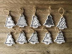 christmas tree ornaments are hanging on a wooden table