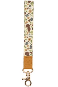 a white strap with flowers on it and a metal hook attached to the bottom of it