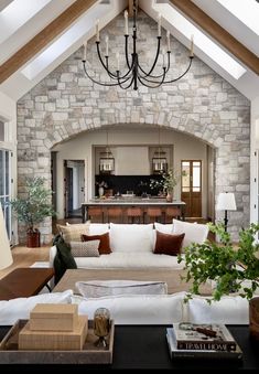 a living room filled with lots of furniture and a chandelier hanging from the ceiling